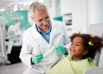 Happy kid on dental chair after repairing tooth
